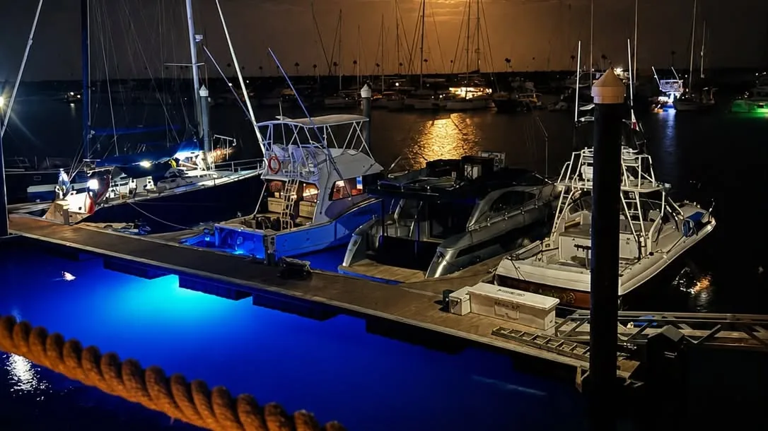 La marina de Vistamar de noche, con la luna reflejada en el agua
